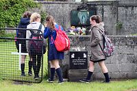 (FILES) This file photo taken on June 09, 2014 shows schoolchildren arrive at a shrine in Tuam, County Galway on June 9, 2014, erected in memory of up to 800 children who were allegedly buried at the site of the former home for unmarried mothers run by nuns. 
"Significant quantities" of baby remains have been discovered in an apparent makeshift crypt at the site of a former Catholic home for unmarried mothers in Ireland, an official commission said on March 3, 2017. The find in the town of Tuam in western Ireland came during extensive excavations by the Commission on Mother and Baby Homes, which was set up following the first claims in 2014 of possible child burials at the site.
 / AFP PHOTO / PAUL FAITH