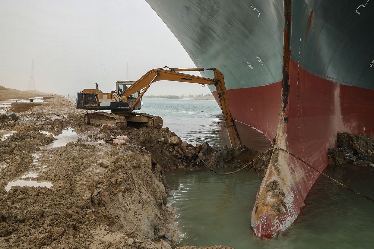 Ein Bagger schaufelt Sand am Ufer des Suezkanal nachdem in der Nacht zum 24. März ein Containerschiff auf Grund gelaufen ist.