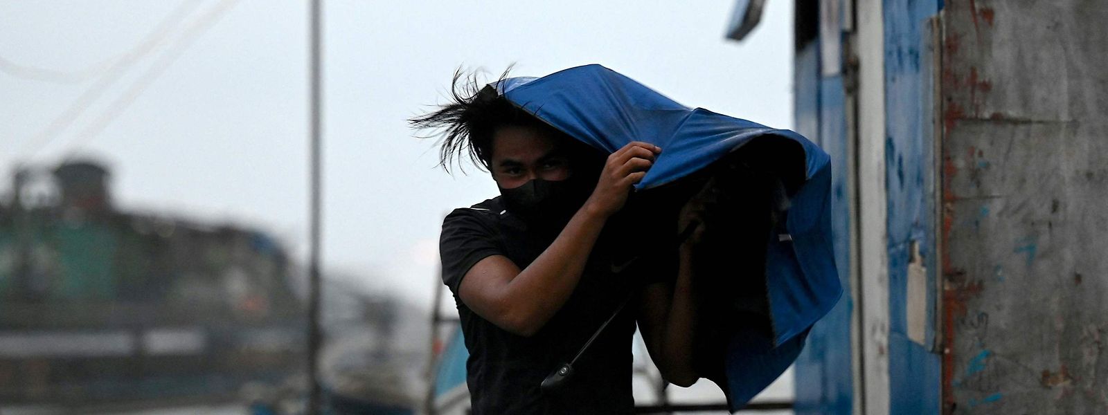 Homem foge do vento em Manila, Filipinas