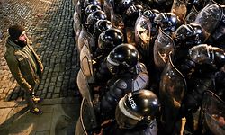 TOPSHOT - A protester confronts Georgian riot police forming a cordon during clashes with protesters near the Georgian parliament in Tbilisi on March 7, 2023. - Georgian police used tear gas and water cannon against protesters Tuesday as thousands of demonstrators took to the streets in the capital Tbilisi to oppose a controversial "foreign agents" bill. (Photo by STRINGER / AFP)