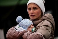 Ukrainian evacuee Luda Oksonenko holds her two month old baby after crossing the Ukrainian-Romanian border in Siret, northern Romania, on March 16, 2022. - More than three million people have fled Ukraine since the start of the invasion, the UN migration agency IOM says. Around half are minors, says the UN children's agency. (Photo by Armend NIMANI / AFP)