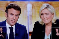 A picture shows screens displaying a live televised between French President and La Republique en Marche (LREM) party candidate for re-election Emmanuel Macron (L) and French far-right party Rassemblement National (RN) presidential candidate Marine Le Pen (R), broadcasted om French TV channels TF1 and France 2, in a viewing room at the studios hosting the debate in Saint-Denis, north of Paris, ahead of the second round of France's presidential election. - French voters head to the polls for a run-off vote between Macron and Le Pen on April 24, 2022. (Photo by Ludovic MARIN / AFP)