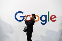 (FILES) In this file photo taken on May 16, 2019, a woman takes a picture with two smartphones in front of the logo of the US multinational technology and Internet-related services company Google as he visits the Vivatech startups and innovation fair, in Paris. - The US administration is stepping up scrutiny of Big Tech firms, which could result in a series of drawn-out legal battles aimed at reining in -- and potentially breaking up -- giants such as Google, Amazon and Facebook. The Department of Justice and Federal Trade Commission have carved out territory for the investigations to set the stage for reviews of the dominance of the largest of the Silicon Valley firms, media reports said on June 3, 2019. (Photo by ALAIN JOCARD / AFP)