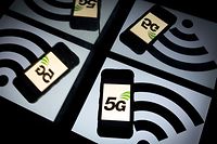 (FILES) In this file photo taken on February 16, 2019 this illustration picture shows the 5 G wireless technology logo displayed on a smartphone and a wireless signal sign displayed by a tablet in Paris. - Apple is expected on October 13, 2020, to unveil a keenly anticipated iPhone 12 line-up starring models tuned to super-fast new 5G telecom networks in an update considered vital to the company's fortunes. (Photo by Lionel BONAVENTURE / AFP)