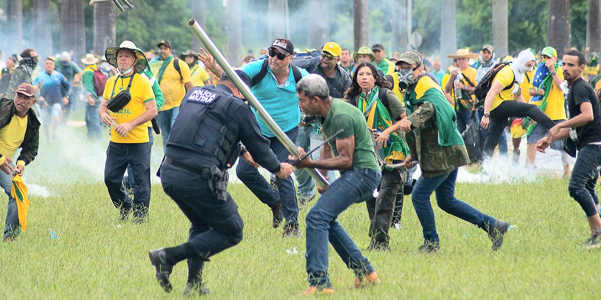 Anhänger des ehemaligen brasilianischen Präsidenten Bolsonaro geraten am 8. Januar in der Hauptstadt mit Polizisten aneinander. Ein Mann schlägt dabei einen Polizisten mit einer Stange.  