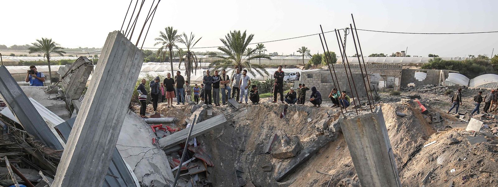 In Khan Yunis im Gazastreifen betrachten Menschen einen Bombentruchter.