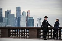 A couple talk to each other at Vorobyovy Hills observation point with skyscrapers of the Moscow International Business Centre (Moskva City) seen in the background in Moscow on October 26, 2020. (Photo by Alexander NEMENOV / AFP)