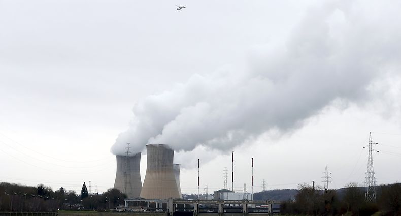 Members of the Belgian civil protection and a helicopter search for a missing 12-year-old boy after he was, according to local media, taken away by a flooded river, near the cooling towers of the Tihange nuclear plant of Electrabel, Belgium, January 24, 2016. REUTERS/Francois Lenoir