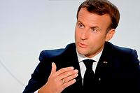 This picture shows a screen displaying French President Emmanuel Macron as he addresses the nation during a televised interview from the Elysee Palace concerning the situation of the novel coronavirus Covid-19 in France, in Paris on October 14, 2020. - Macron orders 9:00 pm-6:00 am curfew for Paris, eight other French cities. The French government said on Wednesday it was re-imposing a state of health emergency to contain the spread of Covid-19. (Photo by Ludovic MARIN / AFP)