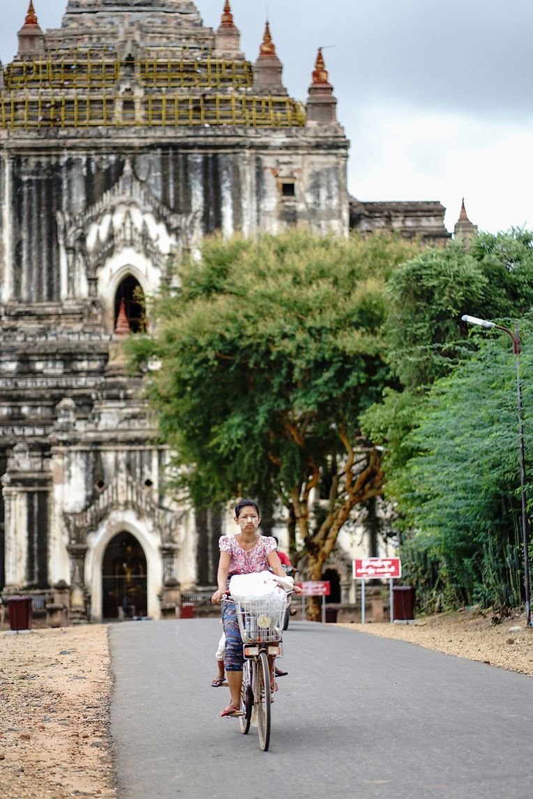 Eine Frau, die vor den Banag-Tempeln Postkarten und Blumen verkauft, fährt am Abend mit ihrem Fahrrad nach Hause.