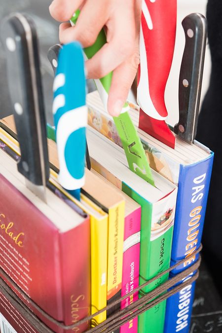 Bücher kreativ zweckentfremden: Ein paar alte Kochbücher zusammenbinden und als Messerblock in der Küche nutzen.