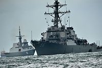 The guided-missile destroyer USS John S. McCain (R), with a hole on its portside after a collision with an oil tanker, is escorted by Singapore Navy RSS Intrepid (L) to Changi naval base in Singapore on August 21, 2017. 
Ten US sailors were missing and five injured after their destroyer collided with a tanker east of Singapore early Monday, the second accident involving an American warship in two months. / AFP PHOTO / Roslan RAHMAN