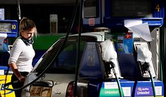A motorist refills the fuel tanks of their vehicle, opposite tapped-off petrol and diesel pumps, at a petrol station in Leyton, east London on September 29, 2021. - British troops are expected to be deployed within days to help ease a fuel supply crisis, the government said on Wednesday, as the retail and hospitality sectors called for foreign workers to be allowed to fill post-Brexit vacancies. (Photo by Tolga Akmen / AFP)