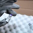 A worker shows a vial of Pfizer-BioNTech Covid-19 vaccine at the arrival of the first shipment in France in the AP-HP central pharmacy on the outskirts of Paris on December 26, 2020. - France's first doses of the Pfizer-BioNTech coronavirus vaccine were delivered early on December 26, 2020, to the Paris hospital system's central pharmacy outside the capital, an AFP journalist saw. A refrigerated truck brought the roughly 19,500 doses from the Pfizer factory in Puurs, northeast Belgium, to Paris, the capital's APHP hospital authority said, with pharmacy chief Franck Huet calling it a "historic" moment in the pandemic. (Photo by STEPHANE DE SAKUTIN / POOL / AFP)