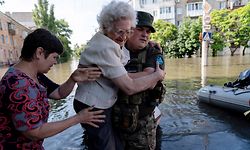 TOPSHOT - A Ukrainian serviceman help local residents during an evacuation from a flooded area in Kherson on June 7, 2023, following damages sustained at Kakhovka hydroelectric power plant dam. Ukraine was evacuating thousands of people on June 7 after an attack on a major Russian-held dam unleashed a torrent of water, inundating two dozen villages and sparking fears of a humanitarian disaster. (Photo by ALEKSEY FILIPPOV / AFP)
