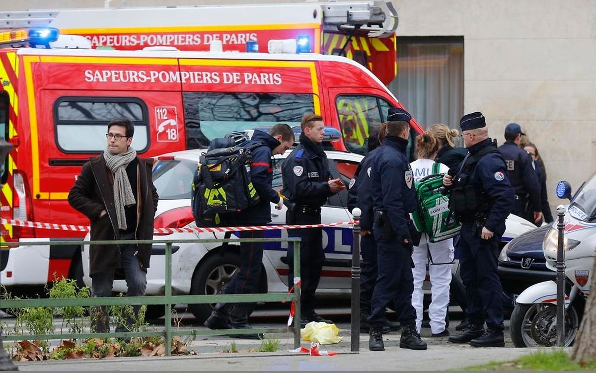 A view shows policemen and rescue members at the scene after a shooting at the Paris offices of Charlie Hebdo, a satirical newspaper, January 7, 2015. Eleven people were killed and 10 injured in shooting at the Paris offices of the satirical weekly Charlie Hebdo, already the target of a firebombing in 2011 after publishing cartoons deriding Prophet Mohammad on its cover, police spokesman said. Five of the injured were in a critical condition, said the spokesman. Separately, the government said it was raising France's national security level to the highest notch. REUTERS/Jacky Naegelen (FRANCE - Tags: CRIME LAW MEDIA)