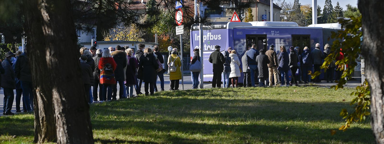 Impfwillige stehen vor einem Impfbus in Wien-Döbling.