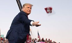 TOPSHOT - US President Donald Trump throws masks to supporters as he arrives to hold a Make America Great Again rally as he campaigns at Orlando Sanford International Airport in Sanford, Florida, October 12, 2020. (Photo by SAUL LOEB / AFP)