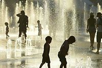 TOPSHOT - Children play in the water fountains at the Place des Arts in Montreal, Canada on a hot summer day July 3, 2018. / AFP PHOTO / EVA HAMBACH