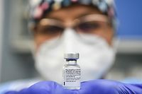 A Cremona Hospital health worker holds a vial of the Pfizer-BioNTech Covid-19 vaccine at the Cremona hospital in Cremona, Lombardy, on December 27, 2020, as Italy begins Covid-19 (novel coronavirus) vaccination. - EU countries on December 27 embarked on a vaccination campaign to defeat the "nightmare" of Covid-19, with the first to be immunised expressing emotion after their jab and leaders hailing a milestone in the fight against the pandemic. (Photo by PIERO CRUCIATTI / POOL / AFP)