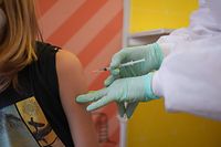 A ten year old girl is vaccinated against the Covid-19 virus at a vaccination centre for children at the museum of natural history in Berlin, on December 15, 2021. - Several European nations started vaccinating children aged five to 11 against Covid-19 in an effort to contain a raging pandemic and keep schools open. (Photo by J�rg Carstensen / POOL / AFP)