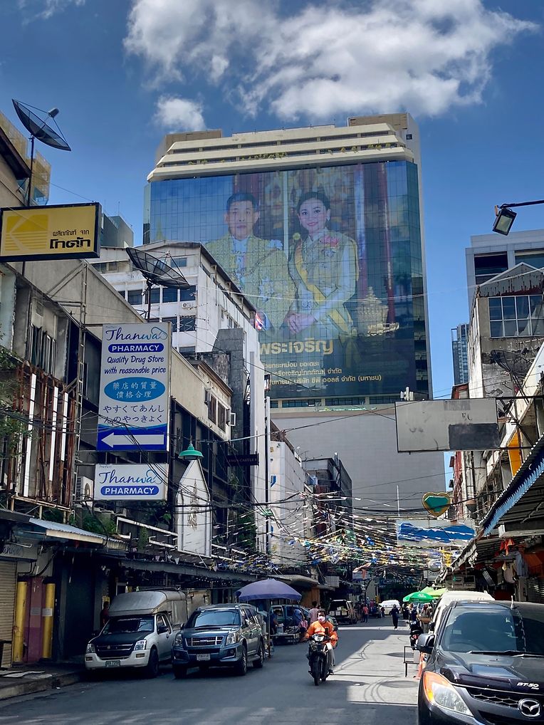 An einer Häuserwand auf der Silom Road prangt ein überlebensgroßes Foto von König Maha Vajiralongkorn und seiner Frau Suthida. 