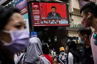 TOPSHOT - Chinese President Xi Jinping is seen on a TV in a street in Hong Kong on October 16, 2022, as he delivers the opening speech of the ruling Communist Party�s 20th party congress in Beijing. (Photo by ISAAC LAWRENCE / AFP)