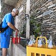 A man collects fresh water at a public fountain in Levo, northwest of Milan, on June 17, 2022 as a mayoral decree ration supplies on tap water amid a severe drought. - 125 towns in the regions of Piedmont and Lombardy have been asked to ration water amid the worst drought to affect northern Italy�s rivers in 70 years. (Photo by Piero CRUCIATTI / AFP)