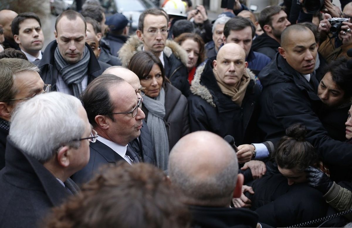 French President Francois Hollande (C) speaks to the press after arriving at the headquarters of the French satirical newspaper Charlie Hebdo in Paris on January 7, 2015, after armed gunmen stormed the offices leaving eleven dead, including two police officers, according to sources close to the investigation. AFP PHOTO / KENZO TRIBOUILLARD