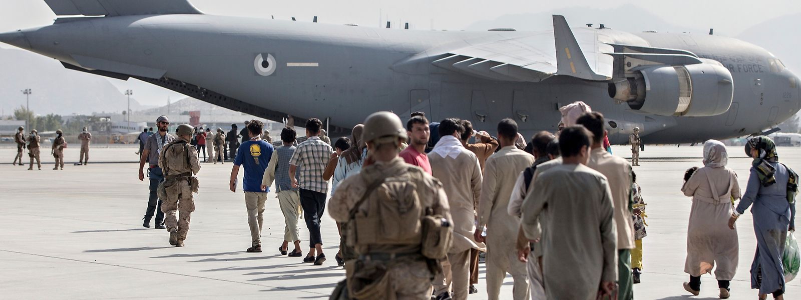 Soldaten der United States Marine Corps begleiten im Rahmen der Operation Allies Refuge Familien am Flughafen Kabul zu einem Evakuierungsflug mit einer Boeing C-17.