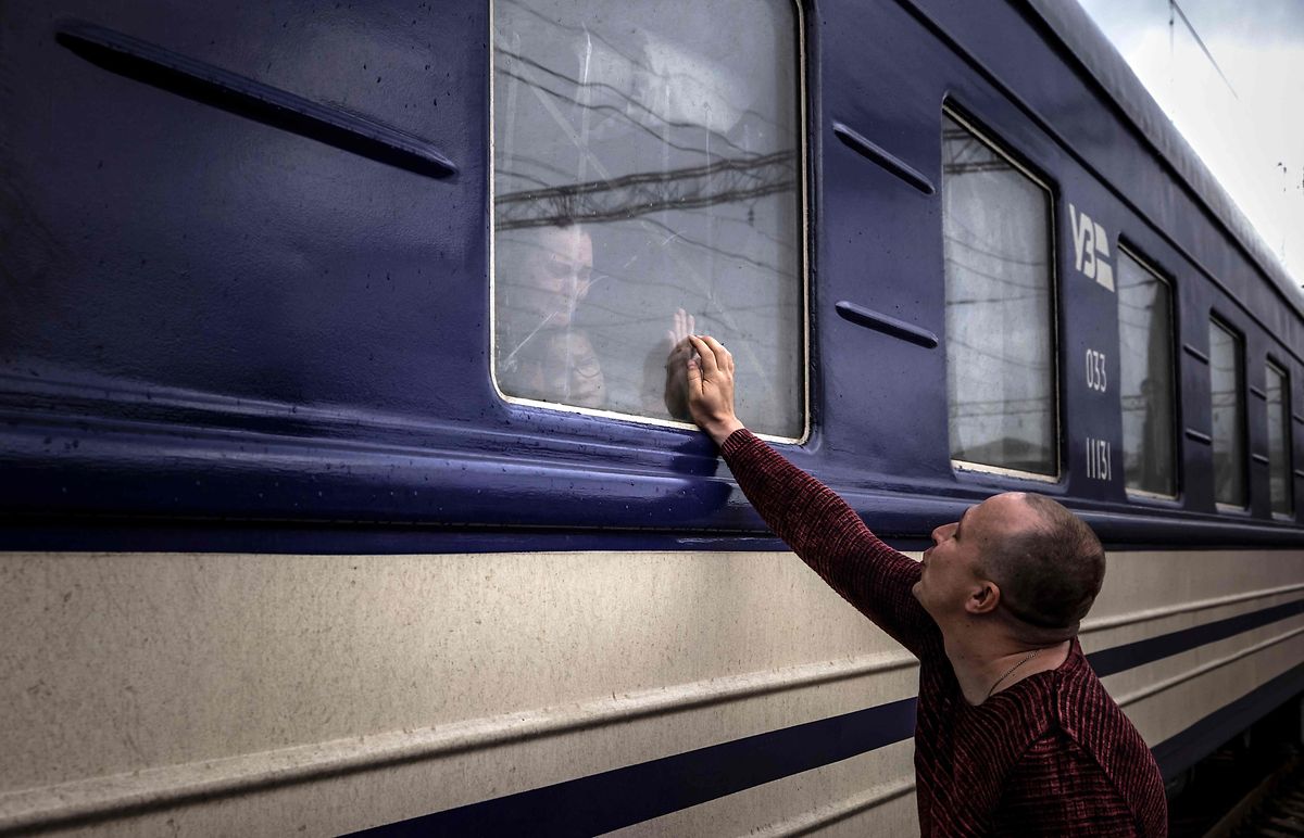A man says goodbye to his family as they flee war-torn Ukraine