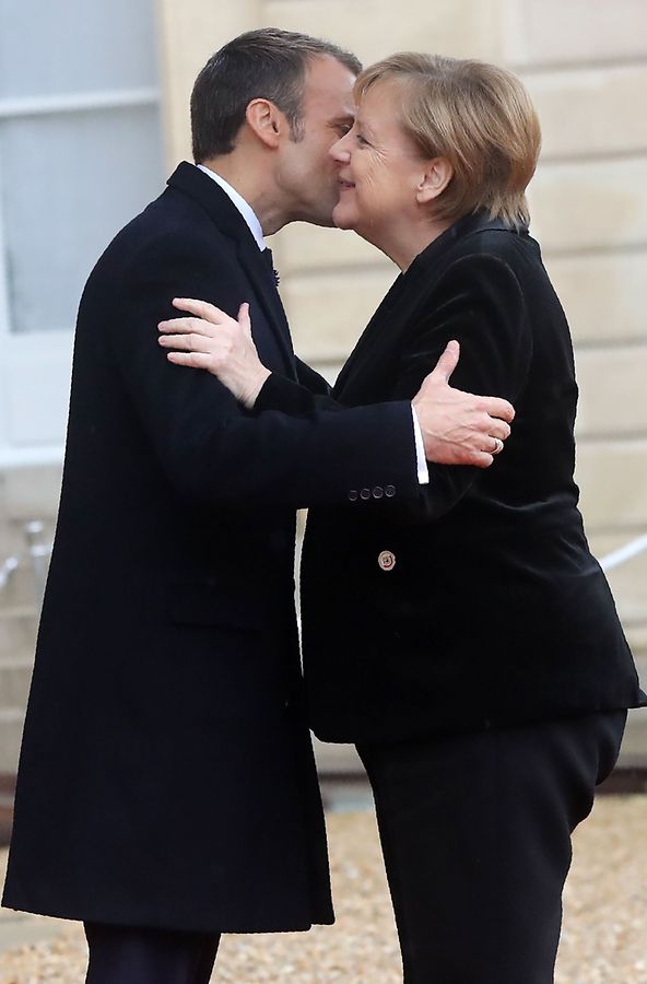 French President Emmanuel Macron (L) welcomes German Chancellor Angela Merkel as she arrives at the Elysee Palace in Paris on November 11, 2018 ahead of the start of commemorations marking the 100th anniversary of the 11 November 1918 armistice, ending World War I. (Photo by Jacques Demarthon / AFP)