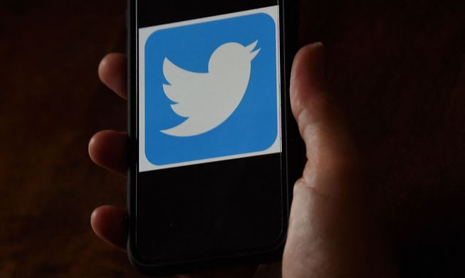 A Twitter logo is displayed on a mobile phone in Arlington, Virginia. Twitter said on May 20, 2021 it was revamping its rules for verified accounts.