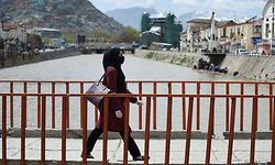 A woman wearing a facemask as a precautionary measure against the COVID-19 novel coronavirus walks across a bridge in Kabul on April 5, 2020. (Photo by WAKIL KOHSAR / AFP)