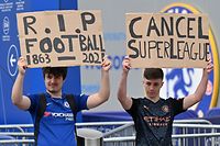 Supporters hold up placards critical of the idea of a New European Super League, outside English Premier League club Chelsea's Stamford Bridge stadium in London on April 20, 2021, ahead of their game against Brighton. - The 14 Premier League clubs not involved in the proposed European Super League "unanimously and vigorously rejected" the plans at an emergency meeting on Tuesday. Liverpool, Arsenal, Chelsea, Manchester City, Manchester United and Tottenham Hotspur are the English clubs involved. (Photo by JUSTIN TALLIS / AFP)