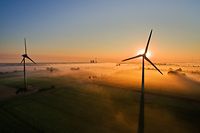ARCHIV - 19.08.2016, Niedersachsen, Hannover: Die aufgehende Sonne taucht über Feldern und Windrädern den Nebel in warmes Licht. Die fünf Nord-Bundesländer und die Windkraftindustrie haben vor einem Kollaps der Branche mit fatalen Folgen für die deutsche Klimaschutzpolitik gewarnt. Foto: Julian Stratenschulte/dpa +++ dpa-Bildfunk +++