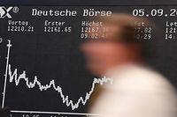 A stock broker walks past the display board of the DAX in Frankfurt am Main, western Germany on September 5, 2018. - Wirecard, a fintech company specializing in electronic payments, is expected to replace the second German bank Commerzbank, in the Dax index on the Frankfurt Stock Exchange, reflecting the digital surge that upsetting the traditional banks. (Photo by Arne Dedert / dpa / AFP) / Germany OUT