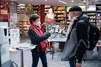 06.12.2021, Saarland, Saarbrücken: Dörte Heinrichs (l) kontrolliert am Eingang ihres Buchgeschäfts einen Impfnachweis. Seit heute gilt im saarländischen Einzelhandel nur noch 2G. Foto: Oliver Dietze/dpa +++ dpa-Bildfunk +++