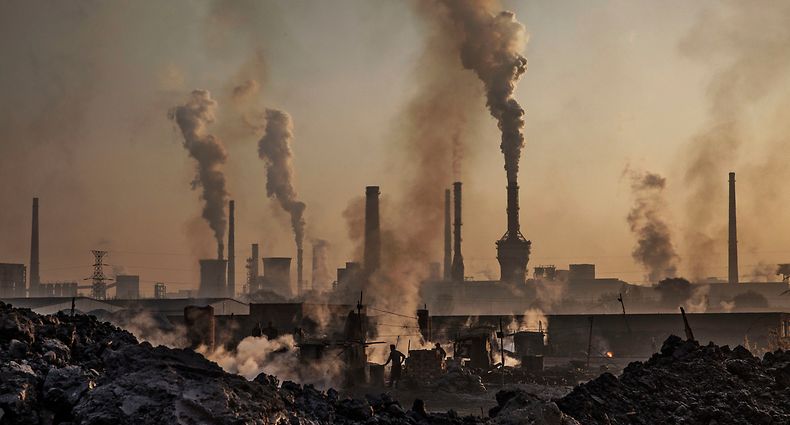 INNER MONGOLIA, CHINA - NOVEMBER 04: Smoke billows from a large steel plant as a Chinese labourer works at an unauthorized steel factory, foreground, on November 4, 2016 in Inner Mongolia, China. To meet China's targets to slash emissions of carbon dioxide, authorities are pushing to shut down privately owned steel, coal, and other high-polluting factories scattered across rural areas. In many cases, factory owners say they pay informal 'fines' to local inspectors and then re-open. The enforcement comes as the future of U.S. support for the 2015 Paris Agreement is in question, leaving China poised as an unlikely leader in the international effort against climate change. U.S. president-elect Donald Trump has sent mixed signals about whether he will withdraw the U.S. from commitments to curb greenhouse gases that, according to scientists, are causing the earth's temperature to rise. Trump once declared that the concept of global warming was "created" by China in order to hurt U.S. manufacturing. China's leadership has stated that any change in U.S. climate policy will not affect its commitment to implement the climate action plan. While the world's biggest polluter, China is also a global leader in establishing renewable energy sources such as wind and solar power. (Photo by Kevin Frayer/Getty Images)