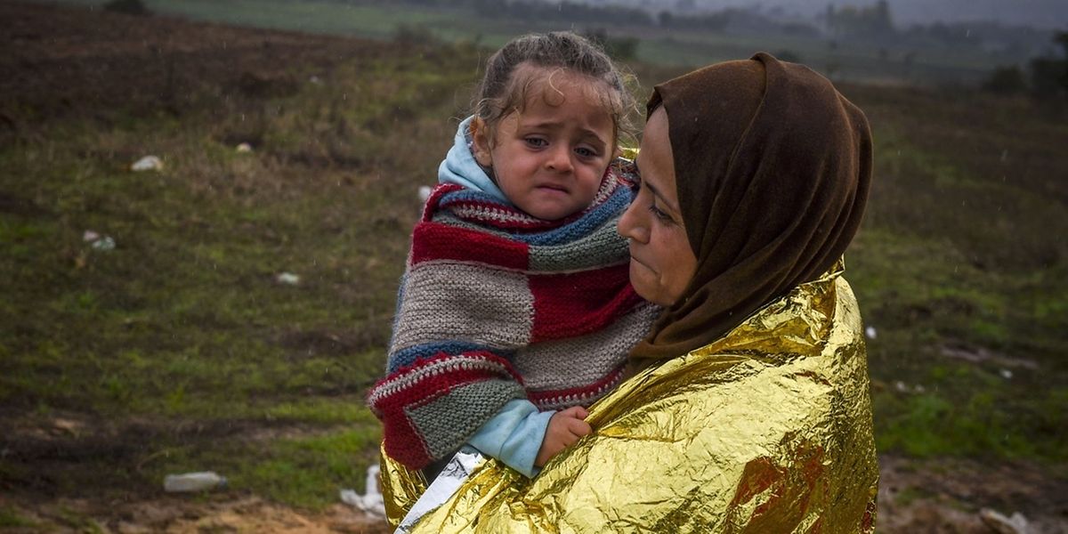 C'était le 20 octobre 2015 près du village de Miratovac à la frontière entre la Macédoine et la Serbie: une couverture de survie sur le dos, une femme et son enfant empruntent la route migratoire des Balkans.