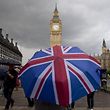 TOPSHOT - A pedestrian shelters from the rain beneath a Union flag themed umbrella as they walk near the Big Ben clock face and the Elizabeth Tower at the Houses of Parliament in central London on June 25, 2016, following the pro-Brexit result of the UK's EU referendum vote.
The result of Britain's June 23 referendum vote to leave the European Union (EU) has pitted parents against children, cities against rural areas, north against south and university graduates against those with fewer qualifications. London, Scotland and Northern Ireland voted to remain in the EU but Wales and large swathes of England, particularly former industrial hubs in the north with many disaffected workers, backed a Brexit. / AFP PHOTO / JUSTIN TALLIS