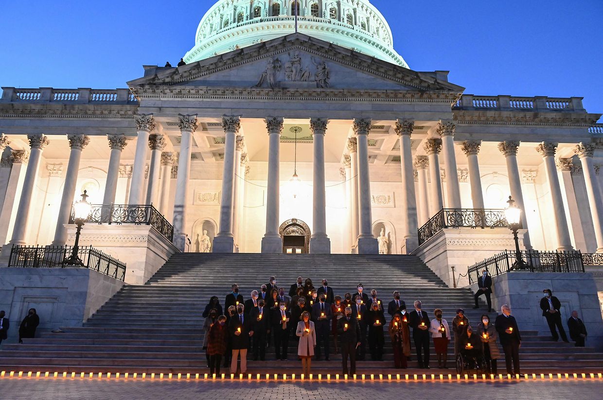US House Speaker Nancy Pelosi (C), Senate Majority leader Chuck Schumer (R) and House Republican Leader Kevin McCarthy (L) hold electric candles as they participate in a vigil in memory of the 800,000 people that have died of Covid-19 in the US, in Washington, DC on December 14, 2021. (Photo by ROBERTO SCHMIDT / AFP)