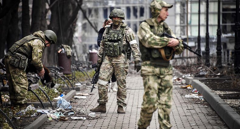 Russian soldiers walks along a street in Mariupol on April 12, 2022, as Russian troops intensify a campaign to take the strategic port city, part of an anticipated massive onslaught across eastern Ukraine, while Russia's President makes a defiant case for the war on Russia's neighbour. (Photo by Alexander NEMENOV / AFP)