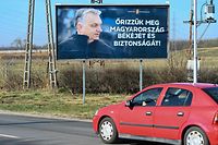 A car is driven in front of an election giant poster of the Hungarian Prime Minister Viktor Orban, can read on it 'Save Hungary's peace and safety!' , in Kisvarda town, eastern Hungary, about 300 km from Hungarian capital Budapest on March 28, 2022. - Facing Hungary's tightest election for years on Sunday, Prime Minister Viktor Orban can count on a win in a party stronghold near the Ukraine border with fears of involvement in the war next door dominating the campaign. (Photo by ATTILA KISBENEDEK / AFP)