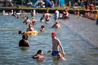 29.06.2021, Kanada, Chestermere: Badegäste kühlen sich an einem Strand von der Hitze ab. Eine Hitzewelle im Westen Kanadas mit Rekordwerten hat nach Angaben der Polizei zu Todesfällen beigetragen. Foto: Jeff Mcintosh/The Canadian Press via ZUMA/dpa +++ dpa-Bildfunk +++