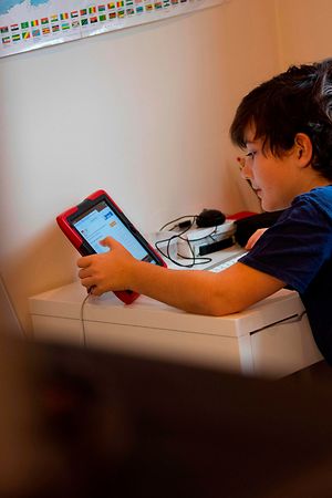 Colin, 10 years old, whose school was closed following the Coronavirus outbreak, does school exercises at home in Washington on March 20, 2020. - As millions of families hunker down amid the coronavirus crisis, the sudden reality of schooling from home risks widening the education gap between those with the means and support to keep up with lessons, and those who risk falling behind. (Photo by Eric BARADAT / AFP)