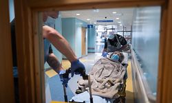 TOPSHOT - Katie Ffolloitt-Powell (R) and Mike Carr of the Patient Transport Services of South Central Ambulance Services move an elderly non-COVID-19 patient from hospital to a care home  near Portsmouth, south England on May 5, 2020. - As the list of recognised Covid-19 symptoms grows, paramedic crews like those with the South Central Ambulance Service are forced to treat every patient as being a potential case, often requiring specialised personal protective equipment (PPE). Paramedics now routinely don what the NHS refers to as Level 2 PPE, like face masks and disposable aprons. (Photo by Leon Neal / POOL / AFP)