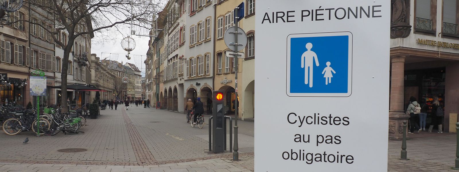 Ein Schild an der Rue des Grandes Arcades in Straßburg fordert Radfahrer zum langsamen Fahren auf. 