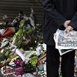 Flowers and candles are placed outside the Le Belle Equipe restaurant along the Rue de Charonne in central east Paris