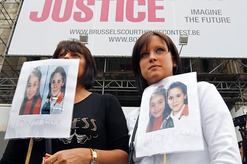 Two women hold pictures of Julie Lejeune and Melissa Russo, two victims of child rapist Marc Dutroux, during a protest outside the Palace of Justice in Brussels  May 10, 2011. Belgian justice authorities have approved a request by the former wife of Belgian paedophile killer Marc Dutroux to be transferred to a convent in France when she is released from prison. Michelle Martin, 51, was arrested in 1996 for her part in helping Dutroux, 54, kidnap six girls, four of whom were killed or died of neglect.   REUTERS/Thierry Roge   (BELGIUM - Tags: CRIME LAW CIVIL UNREST)